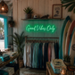 Neon sign 'Good Vibes Only' in a store with clothing racks and surfboards.