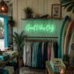 Neon sign 'Good Vibes Only' in a store with clothing racks and surfboards.