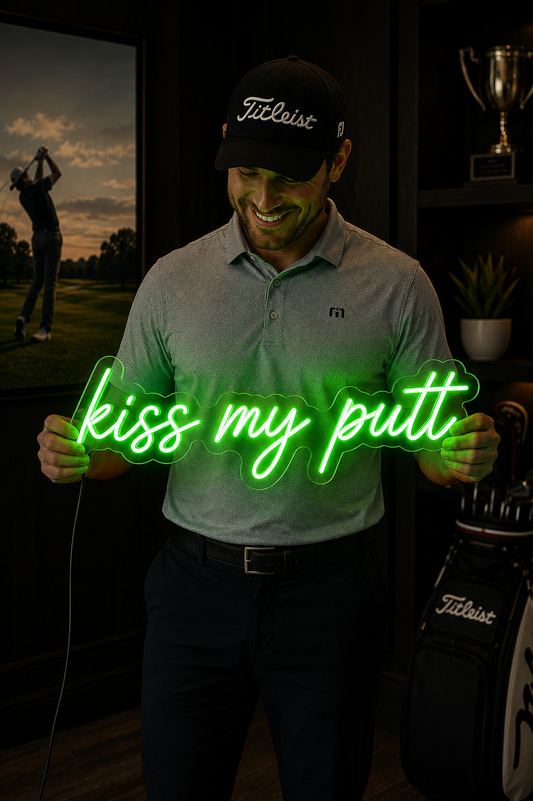 Man holding a neon sign with 'kiss my putt' in a golf-themed room.