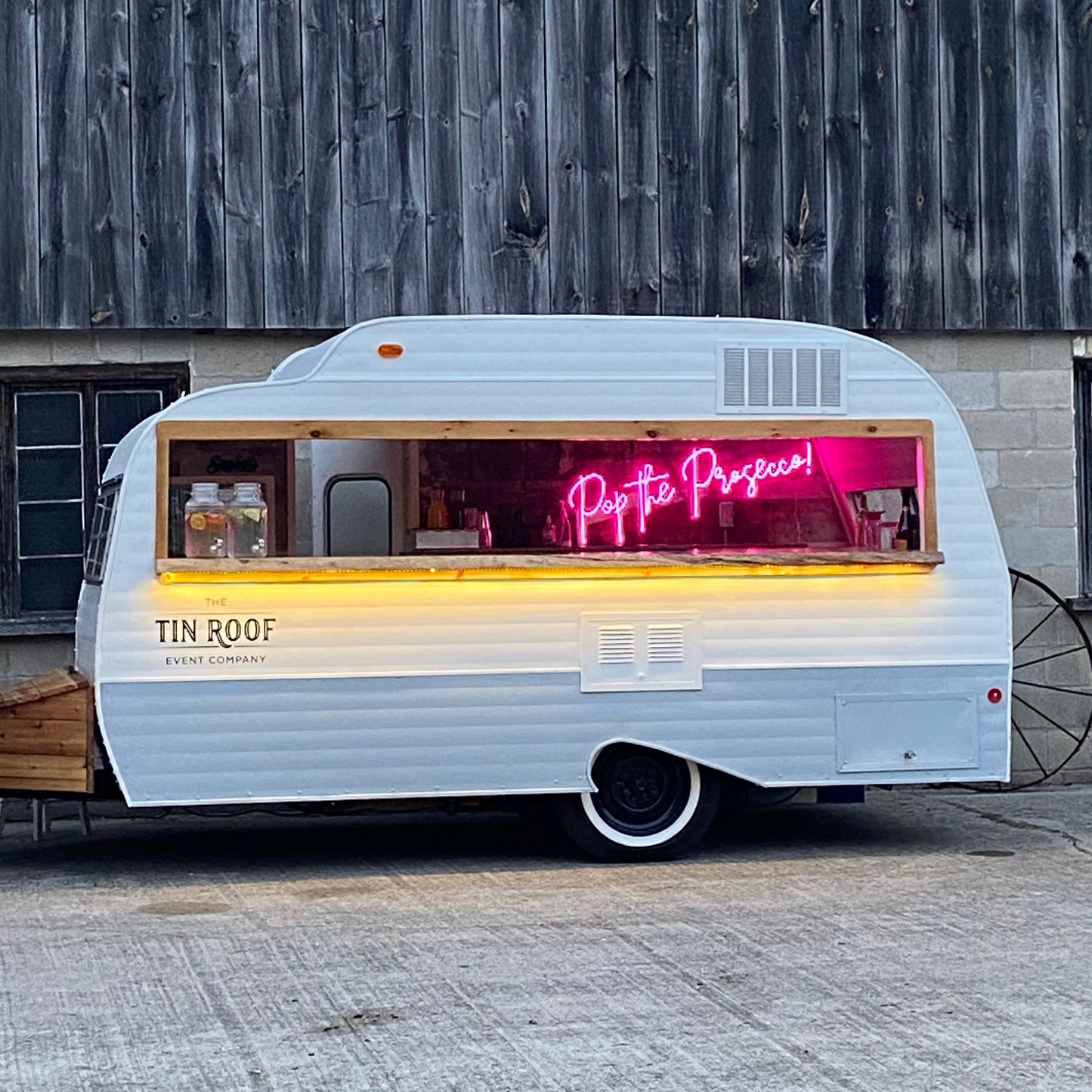 Food truck with a neon sign on a wooden building background
