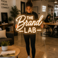 Woman holding a branded neon sign inside of a co-working shared office space