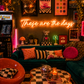 Neon sign that says 'these are the days'  in a retro-themed, maximalist living room with decor elements.