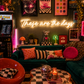 Neon sign that says 'these are the days'  in a retro-themed, maximalist living room with decor elements.