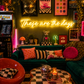 Neon sign that says 'these are the days'  in a retro-themed, maximalist living room with decor elements.