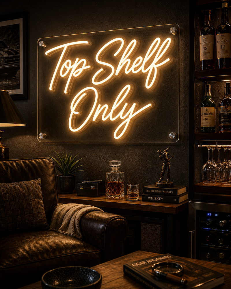 Neon sign reading 'Top Shelf Only' in a bar setting with bottles and glasses.