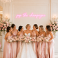 Bride and bridesmaids in pink dresses with floral bouquets in a elegant room.